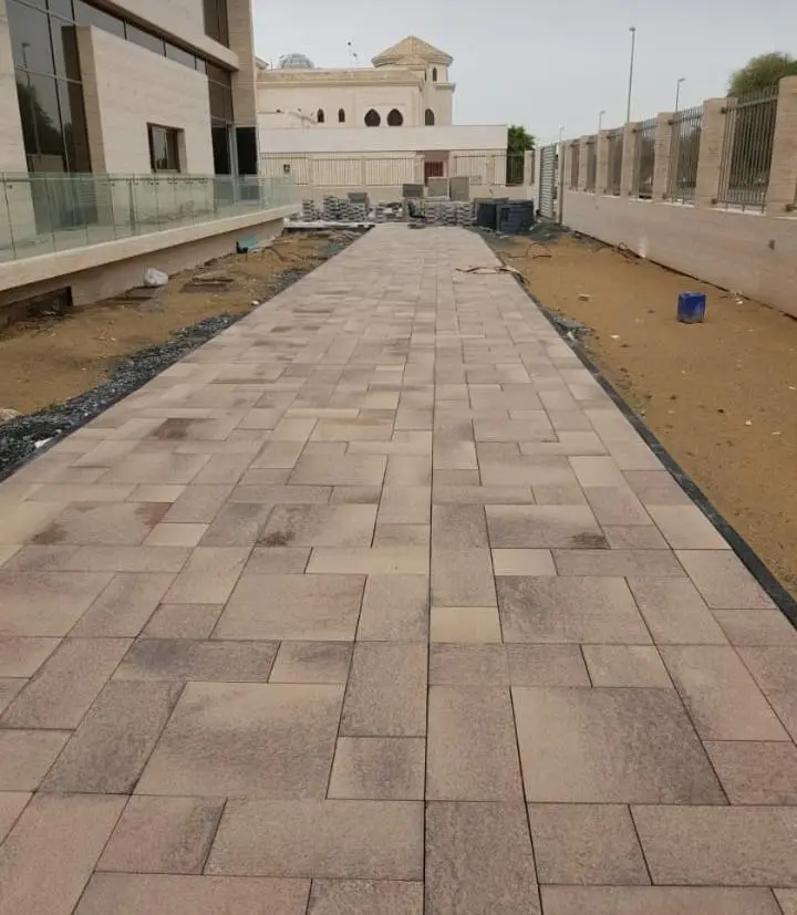 Winding garden pathway made from desert-toned interlocking pasco pavers in Al Ain.