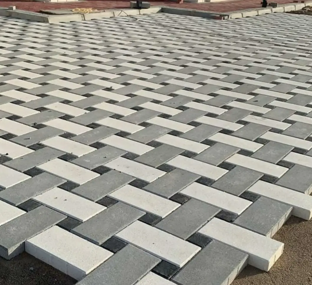 Black and grey interlocking pasco forming a wide, accessible pathway in a public park.
